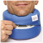 Man justerar höjden på blå Eezyflow sovkrage runt halsen