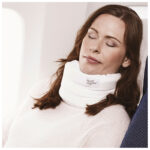 Kvinna sover med vit sovkrage på flygplan