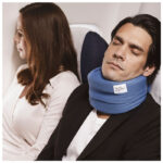 Man sover med blå sovkrage på flygplan bredvid kvinna