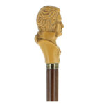 Askstaven med metallring och bystskulptur i sidovy