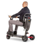 Man sitter på Atto Sport elscooter med Komfort ryggstöd monterat, sedd från sidan