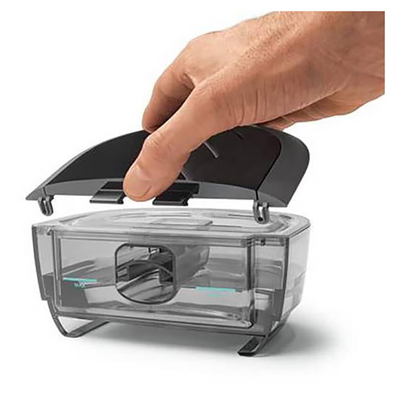 Hand som lyfter locket på DreamStation 2 befuktare