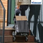 Scala Trappgående sand i trappa Andersen Scala Trappgående med Hera-väska i sand dras uppför en trappa på trestjärniga hjul