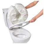 Person monterar Vitility toalettkudde på toalettsits med fyra kardborrband