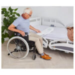 Person som förflyttar sig med glidbräda mellan säng och rullstol