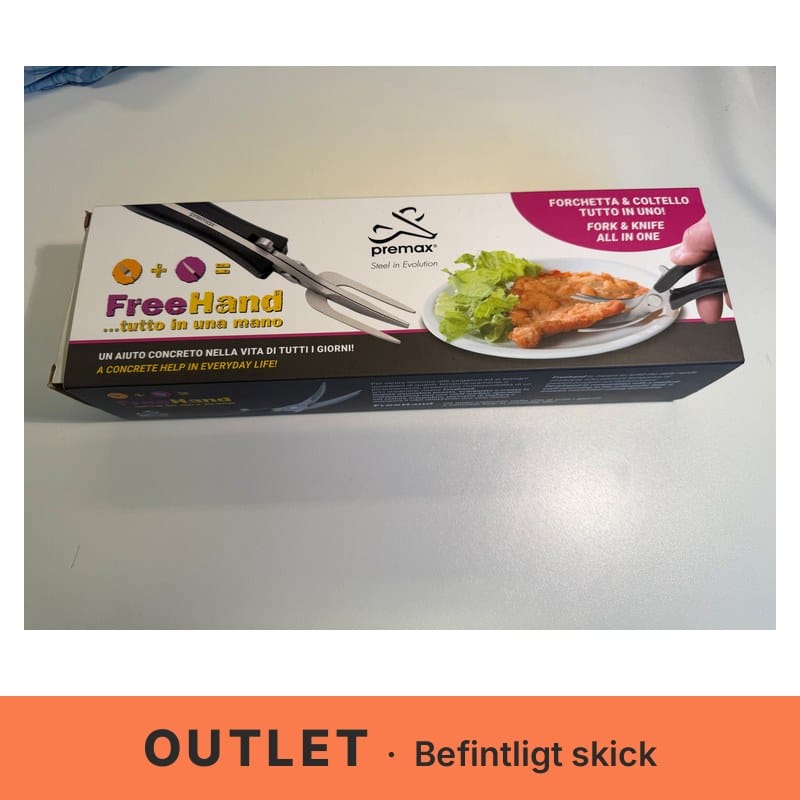 Förpackning till Premax FreeHand med bild på ett saxliknande bestick med svarta handtag, gaffel och knivblad. Bredvid visas en hand som skär en panerad schnitzel på en tallrik med sallad. – outletexemplar i befintligt skick